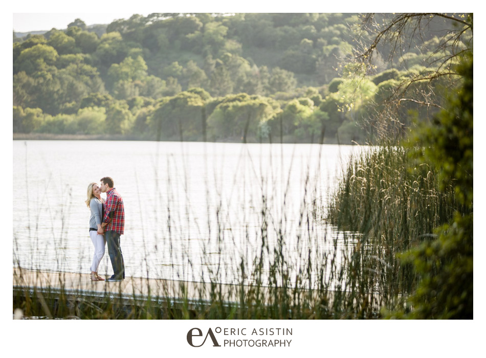 Couple kisses on their engagement session waterside on the docks at Lafayette Reservoir, California
