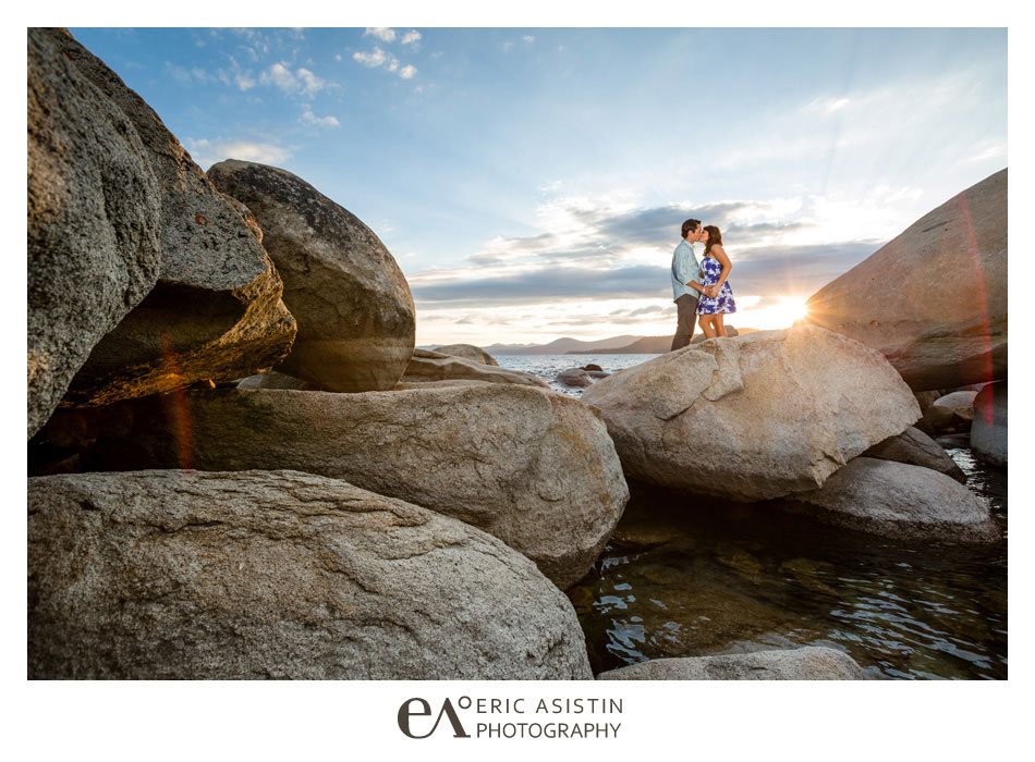 Engaged couple kiss atop the granite rocks in the famed HIdden Beach of North Lake Tahoe.