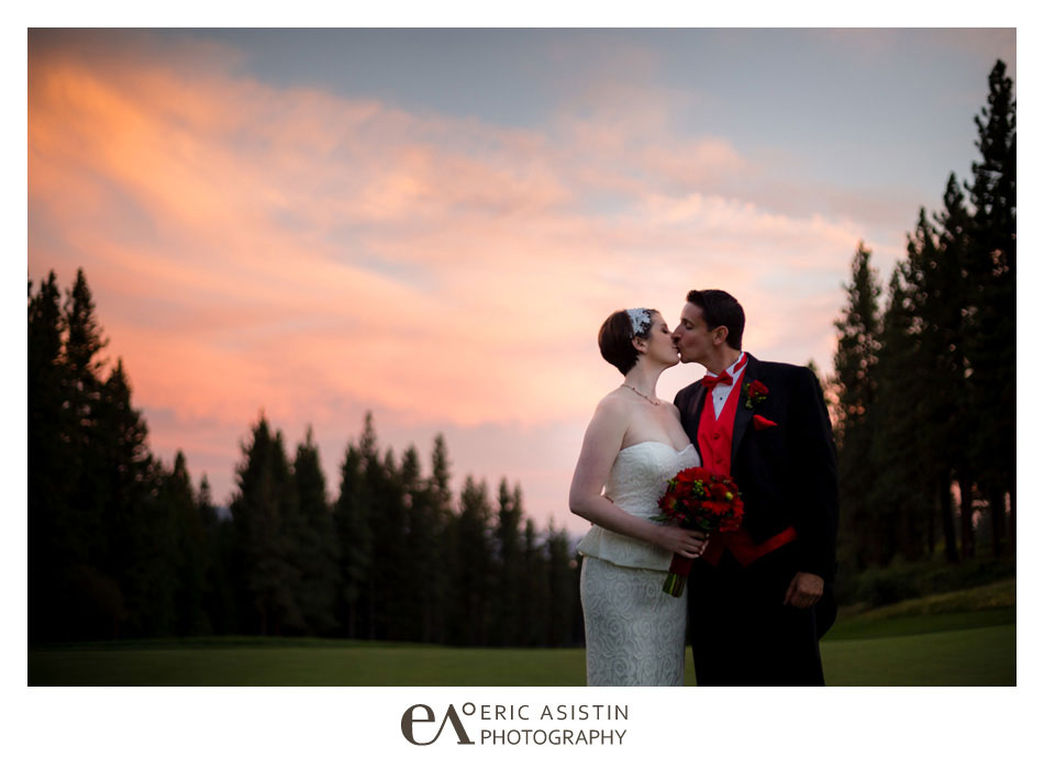 Bride & Groom kiss on the green at The Chateau Incline Village Nevada with a dramatic sunset skyline